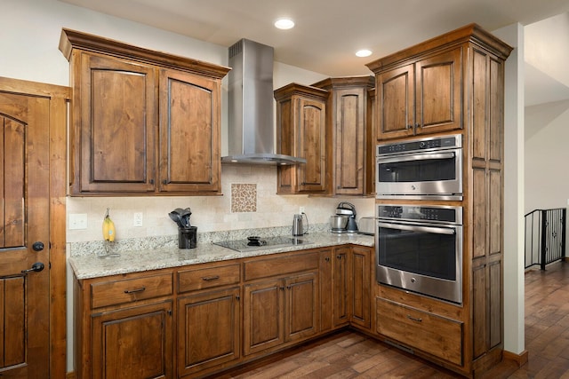 kitchen featuring black electric cooktop, wall chimney range hood, wood-type flooring, and light stone countertops