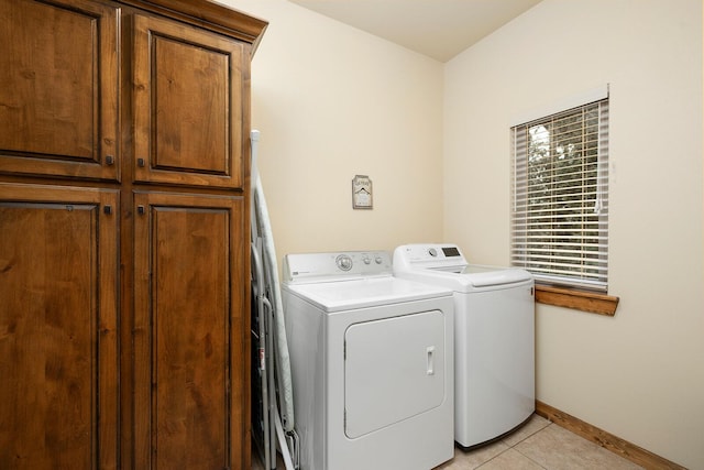 laundry area featuring cabinets, washing machine and dryer, and light tile patterned flooring