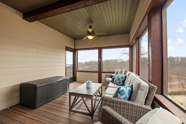 sunroom with ceiling fan, a healthy amount of sunlight, wood ceiling, and beam ceiling