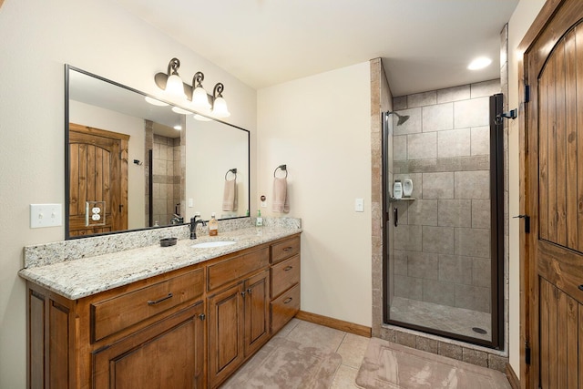 bathroom featuring tile patterned flooring, vanity, and a shower with door