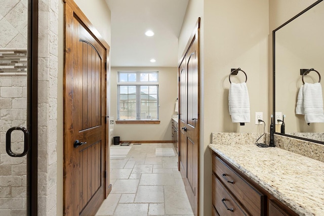 bathroom with vanity and a shower with door