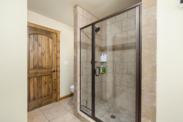 bathroom with tile patterned flooring, a shower with shower door, and toilet