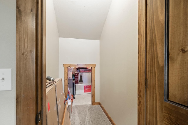 hallway featuring carpet and lofted ceiling