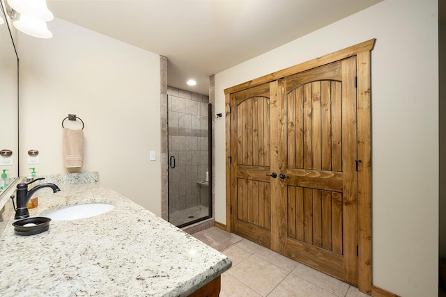 bathroom with tile patterned flooring, vanity, and an enclosed shower