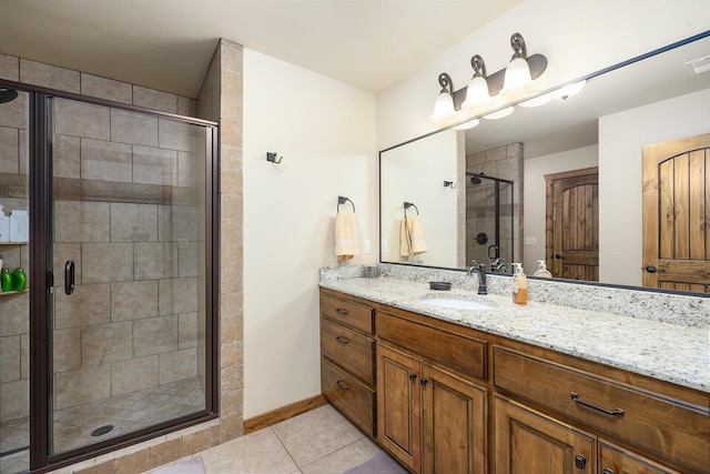 bathroom featuring tile patterned flooring, vanity, and a shower with shower door