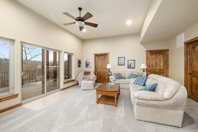 living room featuring a high ceiling, light colored carpet, and ceiling fan