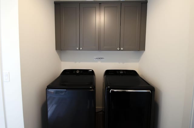 washroom with cabinets and washer and clothes dryer