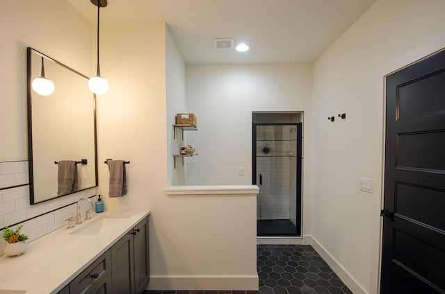 bathroom with an enclosed shower, vanity, decorative backsplash, and tile patterned flooring