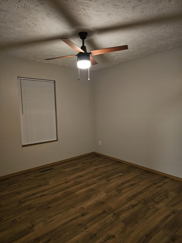 unfurnished room featuring ceiling fan, dark hardwood / wood-style floors, and a textured ceiling