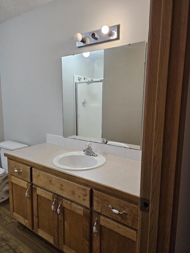 bathroom featuring vanity, hardwood / wood-style flooring, toilet, and walk in shower