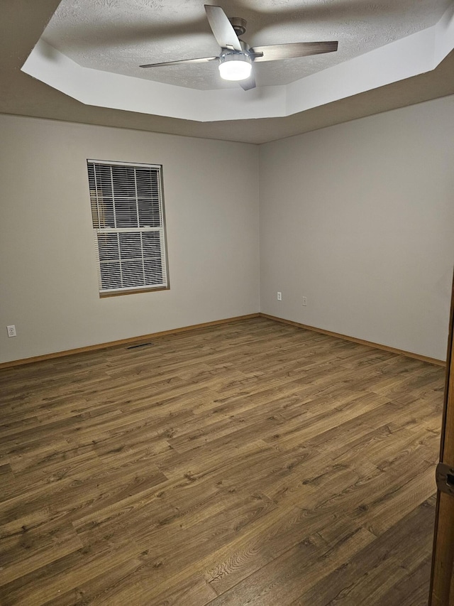 spare room with dark hardwood / wood-style flooring, a textured ceiling, and ceiling fan