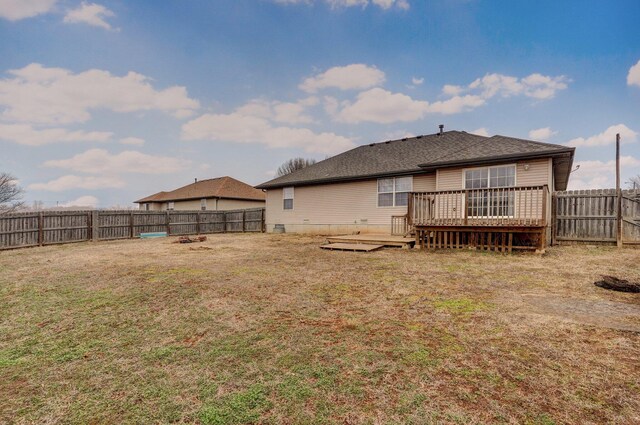 back of house featuring a wooden deck and a lawn