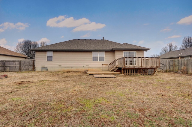 back of property featuring a wooden deck and a yard