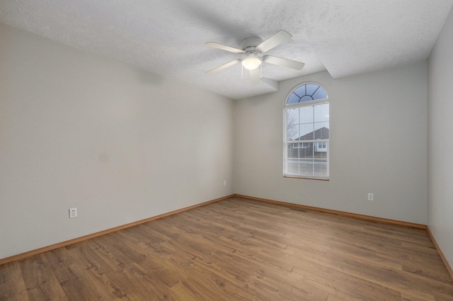 spare room featuring ceiling fan, a textured ceiling, and light wood-type flooring