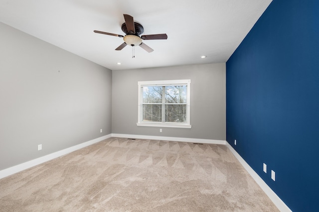 unfurnished room featuring light colored carpet and ceiling fan