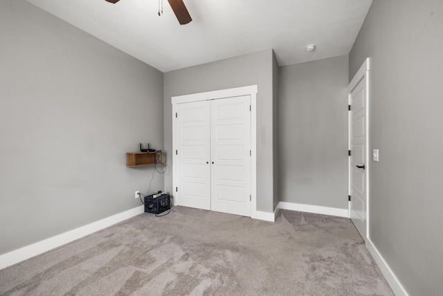 unfurnished bedroom with light colored carpet, a closet, and ceiling fan