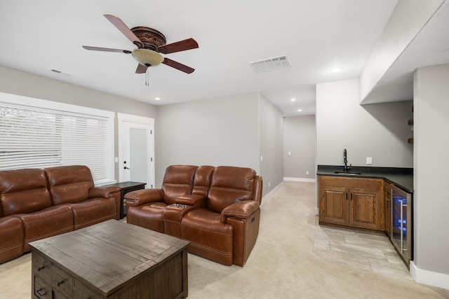 living room with light colored carpet, indoor wet bar, beverage cooler, and ceiling fan