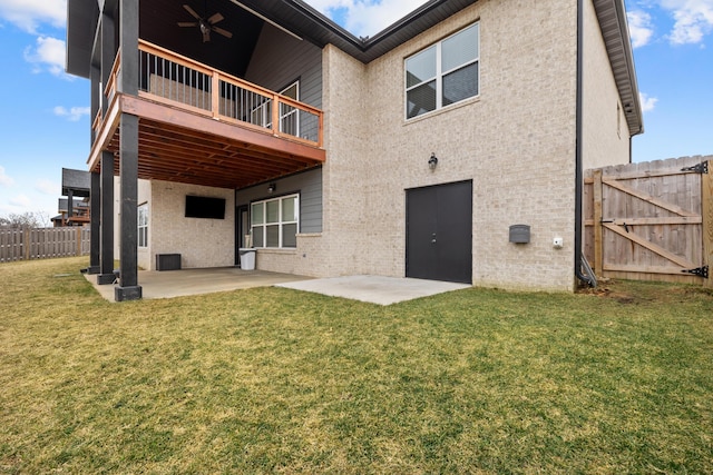 back of property with ceiling fan, a patio, and a lawn