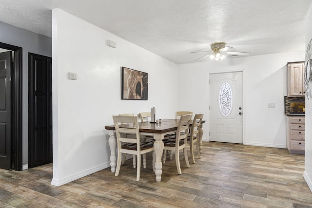 dining room featuring ceiling fan, dark hardwood / wood-style flooring, and a textured ceiling