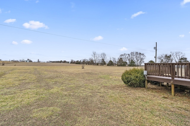 view of yard with a rural view and a deck