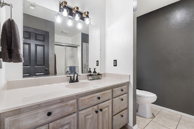 bathroom featuring vanity, toilet, a shower with shower door, and tile patterned flooring