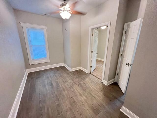 spare room with dark hardwood / wood-style floors and ceiling fan