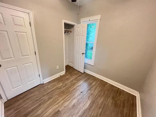 unfurnished bedroom with dark wood-type flooring