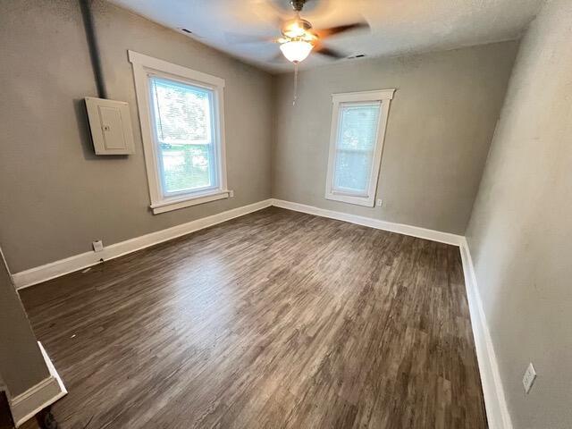 unfurnished room with dark wood-type flooring and ceiling fan