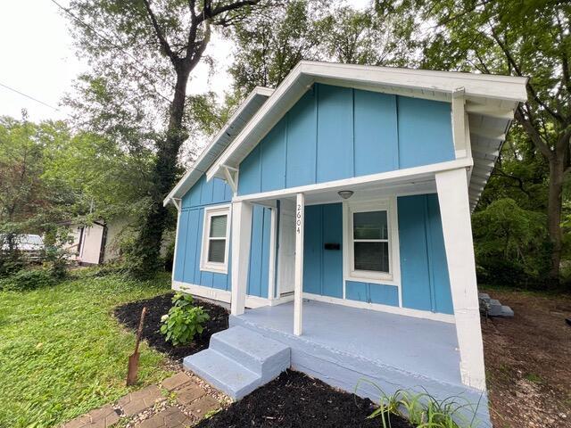 view of front of house with covered porch and a front lawn