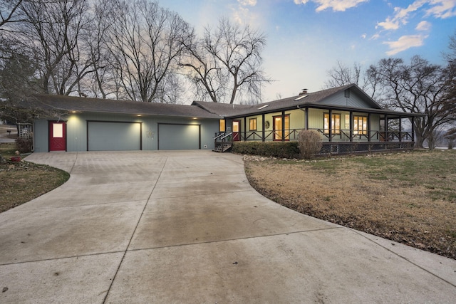 ranch-style home with a porch, a garage, and a lawn