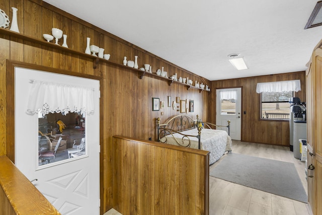 bedroom with wood walls and light wood-type flooring