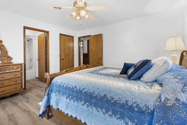 bedroom featuring connected bathroom, light hardwood / wood-style flooring, and ceiling fan