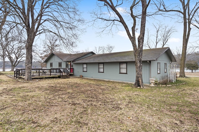 rear view of property featuring a deck and a lawn