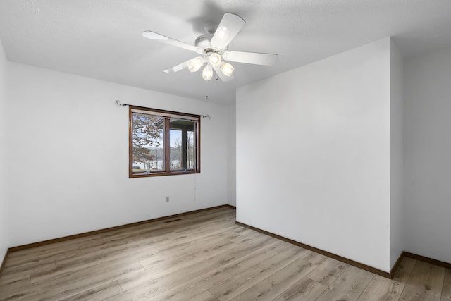 spare room with ceiling fan and light wood-type flooring