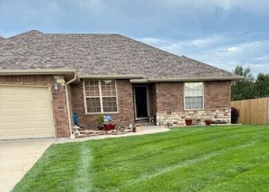 single story home featuring a garage and a front yard