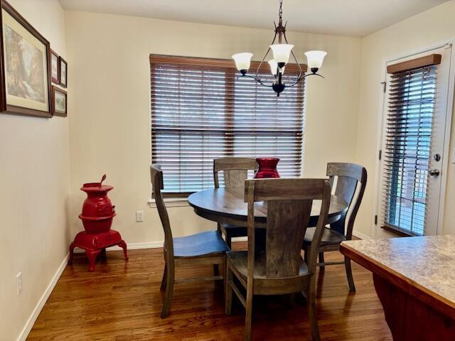 dining space with dark hardwood / wood-style floors and a chandelier