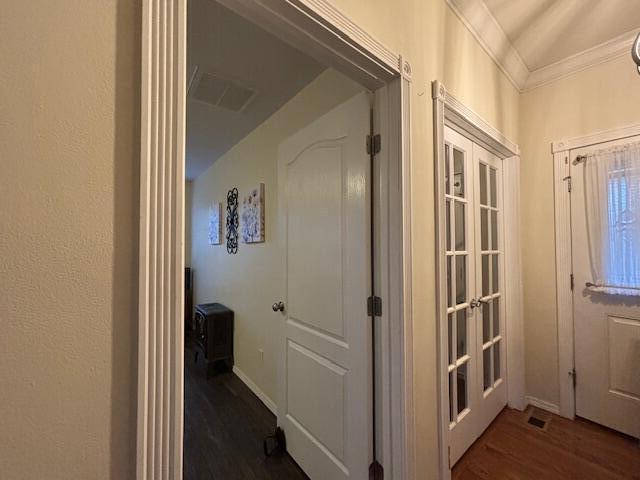 hallway with ornamental molding and dark wood-type flooring