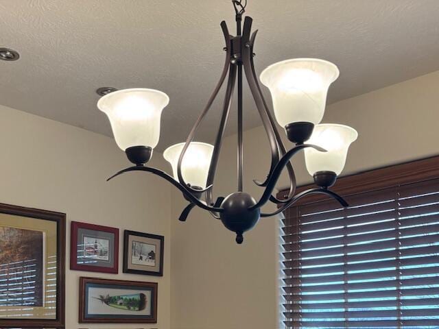 room details featuring an inviting chandelier and a textured ceiling