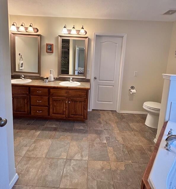 bathroom featuring vanity, a bathtub, and toilet