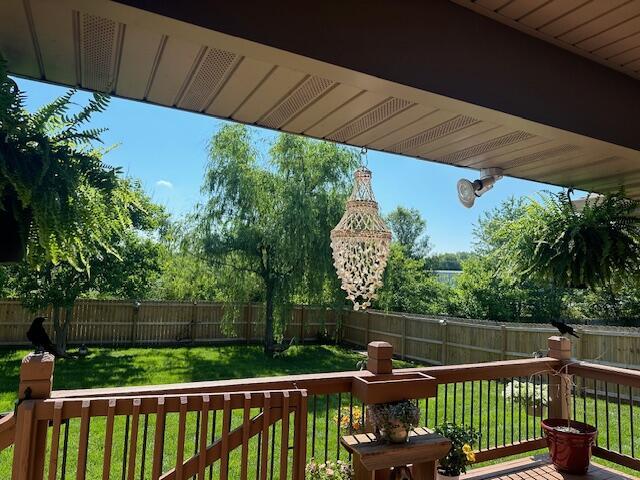 wooden deck featuring a lawn