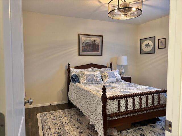 bedroom with dark hardwood / wood-style floors