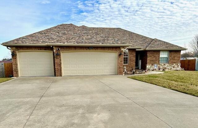 ranch-style home featuring a garage and a front lawn