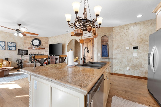 kitchen featuring stainless steel appliances, white cabinetry, a kitchen island with sink, and sink