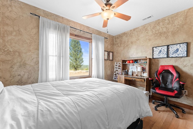 bedroom with ceiling fan and hardwood / wood-style floors