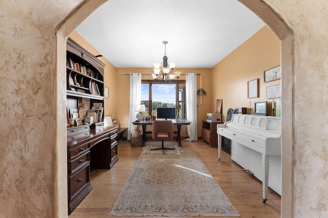 office area featuring an inviting chandelier and light wood-type flooring