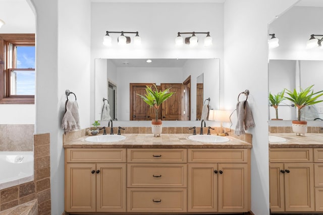 bathroom with vanity and tiled bath