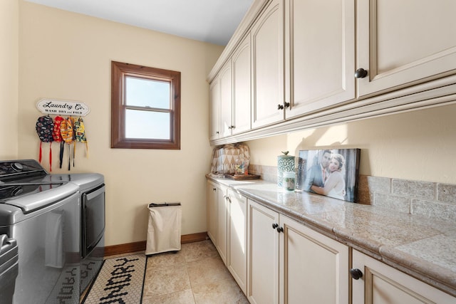 washroom with cabinets, washer and dryer, and light tile patterned floors