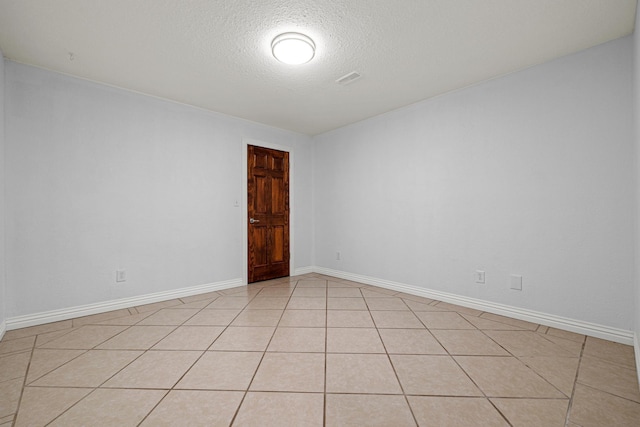 unfurnished room with light tile patterned floors and a textured ceiling