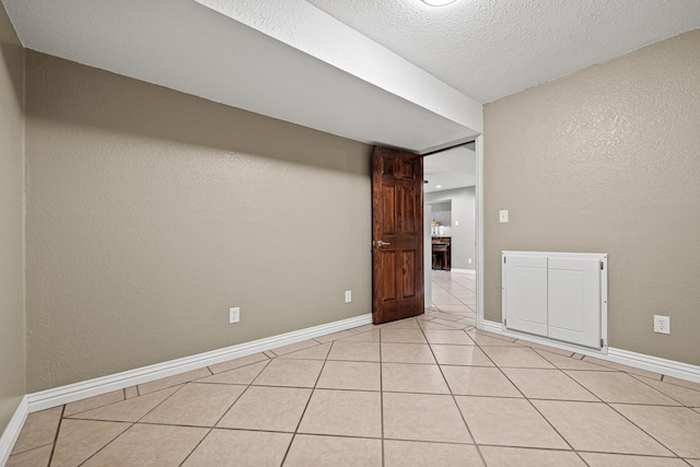 unfurnished room with light tile patterned floors and a textured ceiling