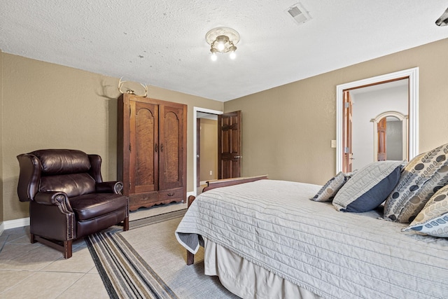 tiled bedroom featuring a textured ceiling